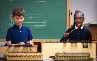 Two kids play xylophones