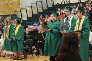 Graduates standing with diplomas 