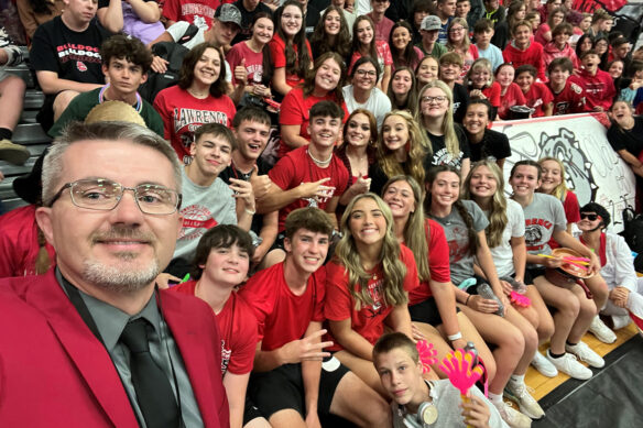 Robbie Fletcher takes a selfie with several students during an assembly