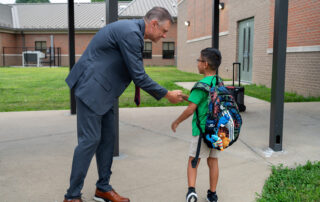 Charles Broughton talks to a student wearing a backpack