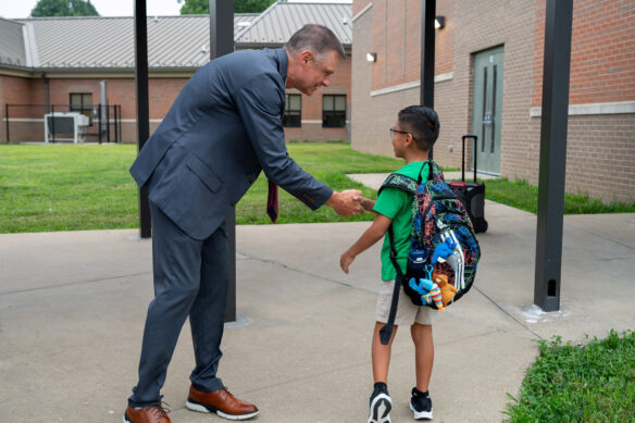 Charles Broughton talks to a student wearing a backpack